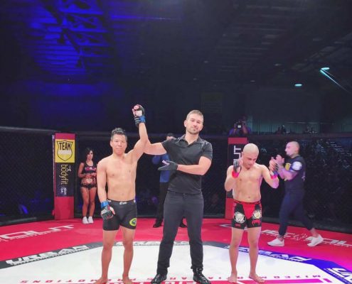 Referee raising hand of winning MMA fighter in cage after match at UFN 12 event in Sydney, August 2017